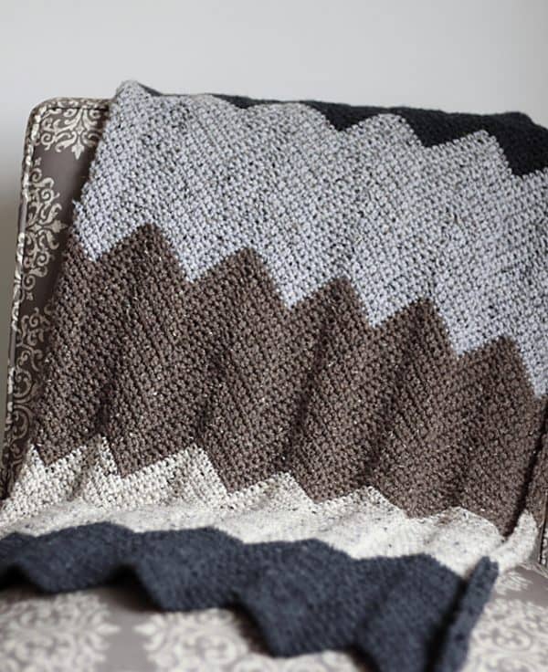 Gray brown and white blanket hanging from chair