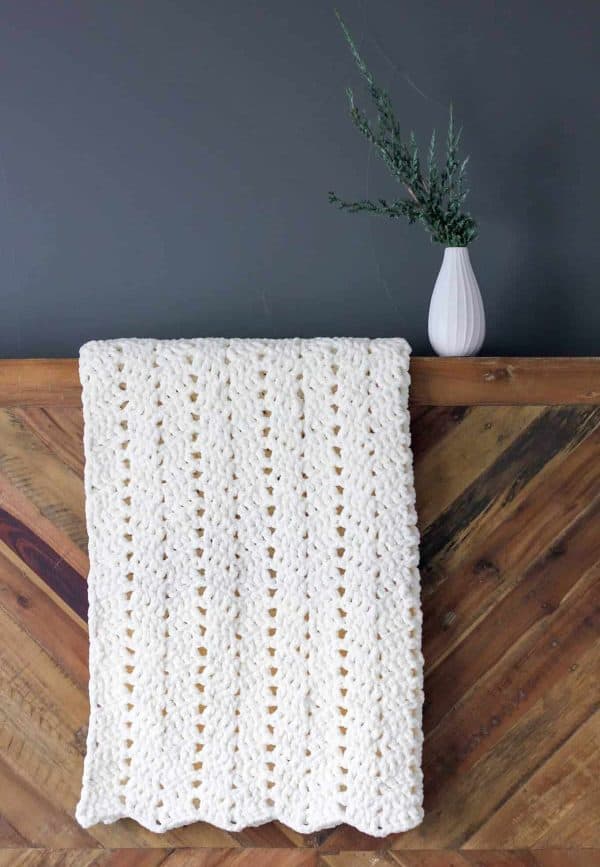 White chunky blanket hanging from wall.