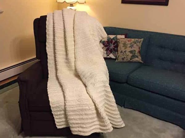 Large white blanket on top of a chair.
