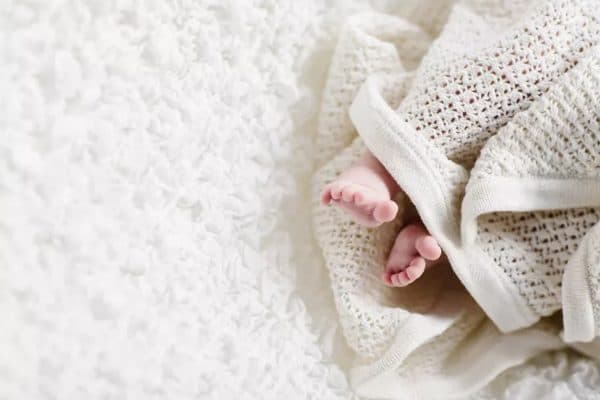 Closeup of a baby blanket surrounding baby feet