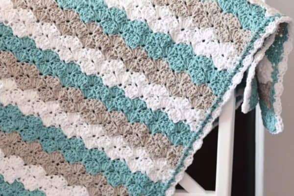Closeup of a baby blanket in white green and gray colors