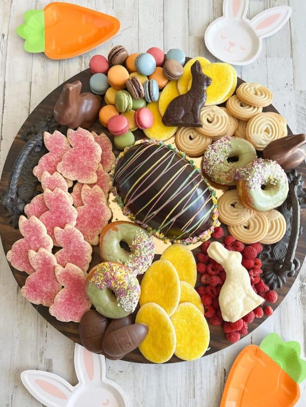 A large chocolate egg in the center with cookies and donuts surrounding it from A New Dawnn.