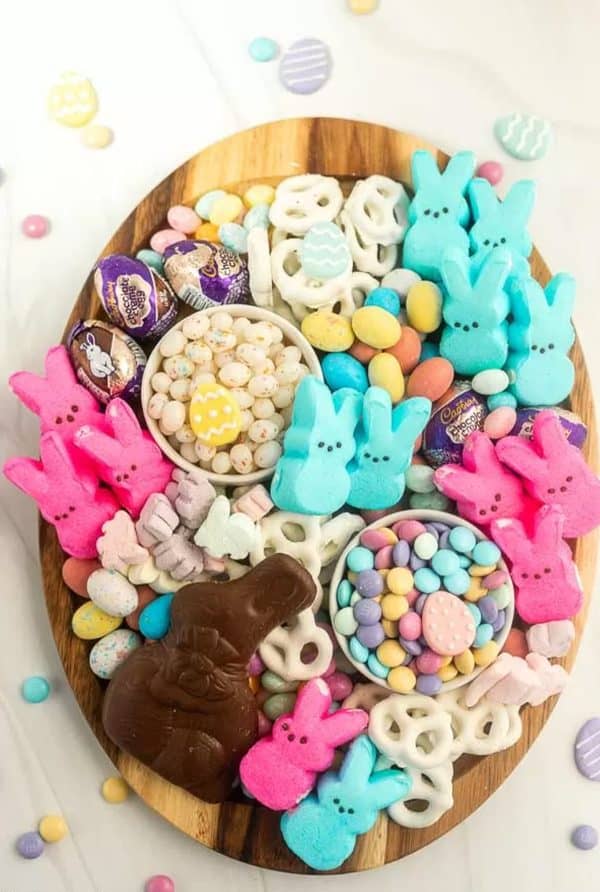 A cheap bright board with bowls of treats and marshmallow peeps from Desserts on a Dime.