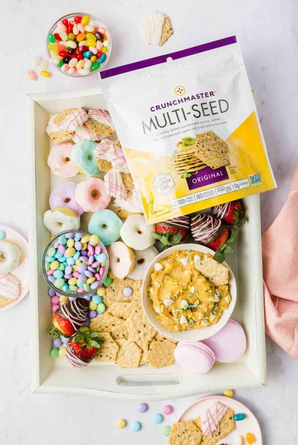 A gluten free Easter candy charcuterie board with donuts, chocolate covered strawberries and.a special dip from Good For You Gluten-Free.