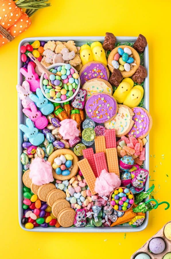 Using a cookie tray, this bright Easter candy charcuterie board is full of cookies, candies, and cotton candy from Wishes and Dishes.