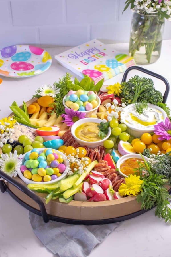 Easter charcuterie board ideas from Aleka's Get-together is a bright board with colorful hard boiled eggs, a variety of dips and candies.