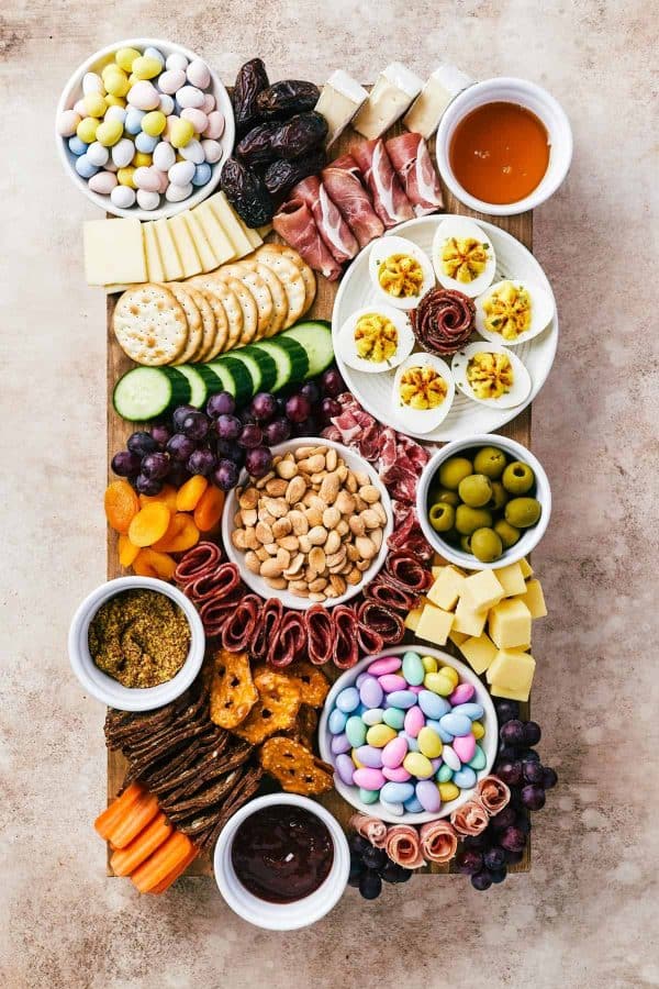 Easter charcuterie board ideas from easy weeknight recipes that includes deviled eggs, a variety of meat, crackers, and many small bowls of other delicious options.