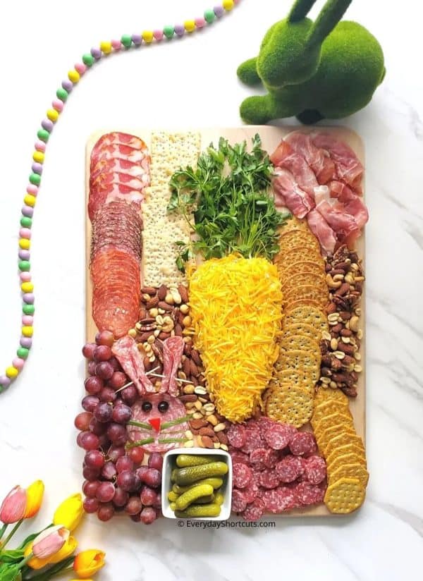 Easte charcuterie board ideas from Everyday shortcuts includes a large cheese ball shaped like a carrot and other traditional charcuterie foods.