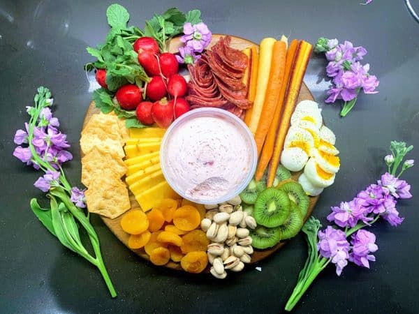 Easter charcuterie board ideas from healthy foodie. Including simple fruits like kiwi and dried apricots, hard boiled eggs, and more.