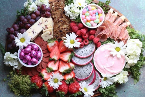 A unique Easter charcuterie board idea from snowflakes and coffeecakes that includes dragonfruit and sweet strawberry cream cheese dip.