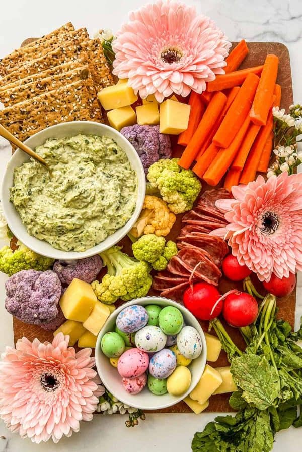 Easter charcuterie board ideas from this healthy table includes a variety of vegetables and flowers for accent.