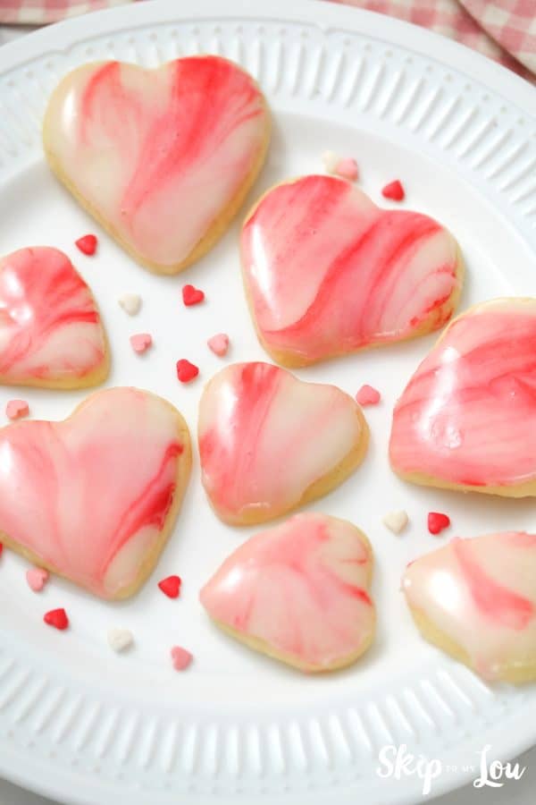 Heart shaped sugar cookie topped with a white, pink and red marbled icing, by Skip to my Lou.