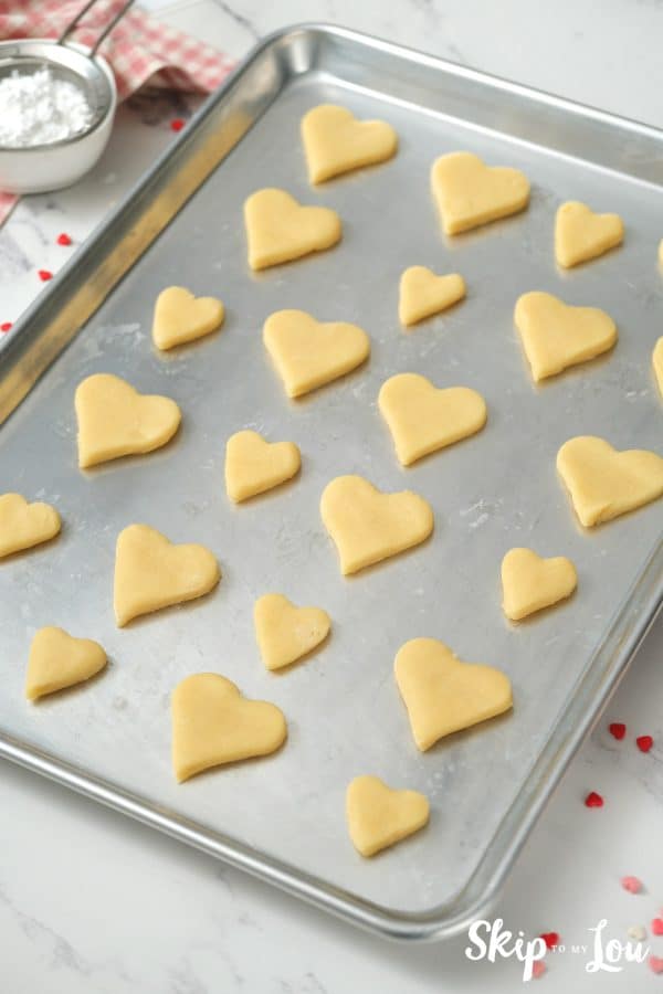 22 heart shaped cookies sitting in rows on a baking sheet before baking, by Skip to my Lou.