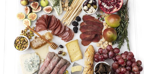 A charcuterie board created on the counter for Beef Loving Texas with roast beef, figs, honey suckle, and more.