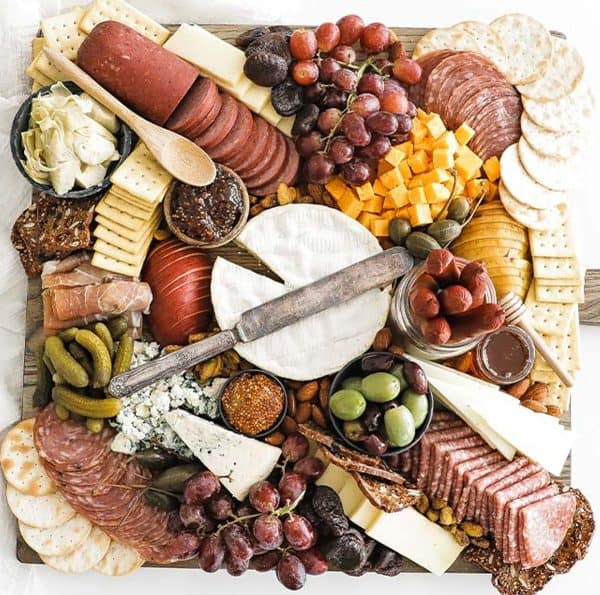 Billy Parisi creates one of the best meat charcuterie board ideas with a variety of meats, cheeses, and some fruit for sweetness.