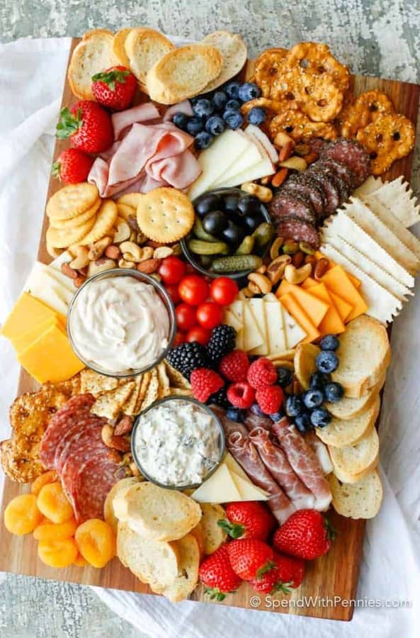 Spend with pennies has a mix of fresh and dried fruit, bread sclies, dips, with cheeses like cheddar, parmesan, and fruit.