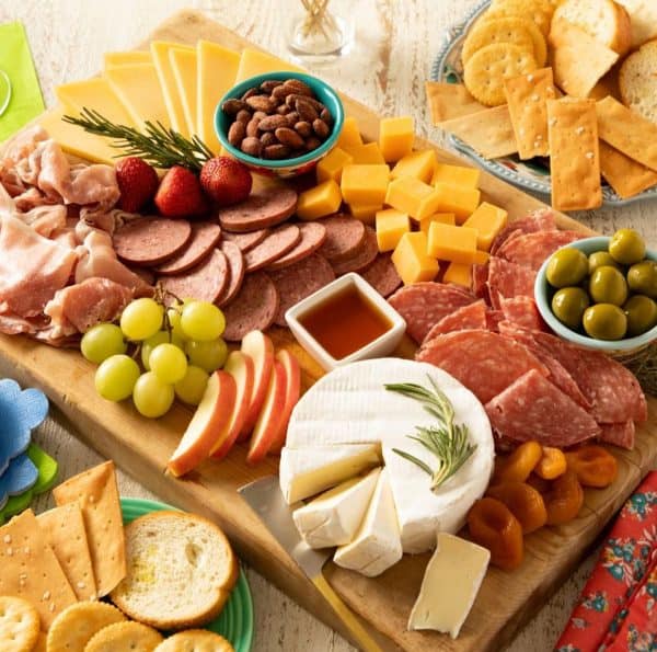 Pioneer Woman creates a simple meat charcuterie board with brie, cheddar, crackers, and more.
