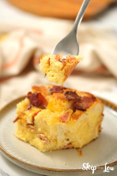 serving of egg strata on a plate with a fork holding a bite of it