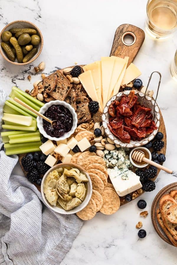 Fork in the Kitchen creates a board with celery, crackers, artichoke, and dip.