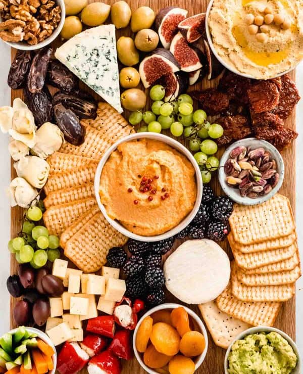 Wholefood Soulfood Kitchen veggie charcuterie board with crackers, fruit, cheese, and dips.