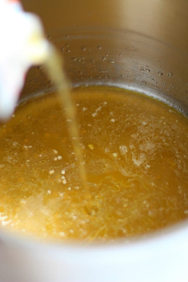 Vegetable broth being poured into a silver soup pot, by Skip to my Lou.