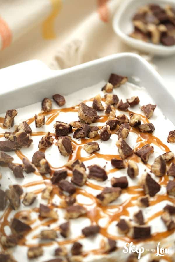 Chocolate cake with whipped topping, drizzled with caramel sauce and topped with chocolate covered toffee bits, by Skip to my Lou.