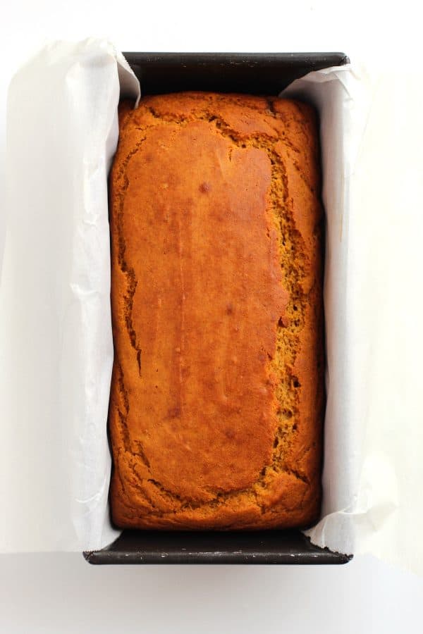 Baked loaf of gluten free pumpkin banana bread in a loaf pan, by Skip to my Lou.