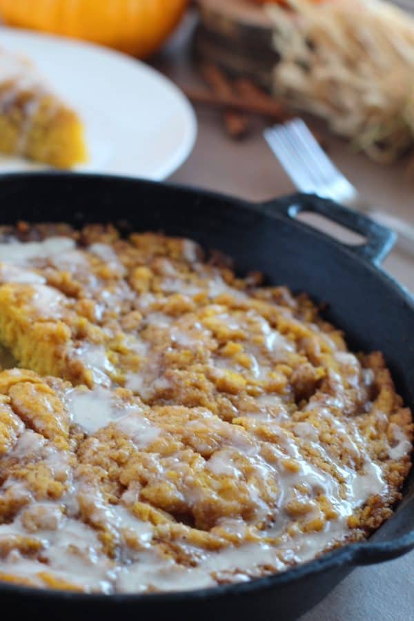 Pumpkin cinnamon roll cake baked in a black cast iron skillet, by Skip to my Lou.
