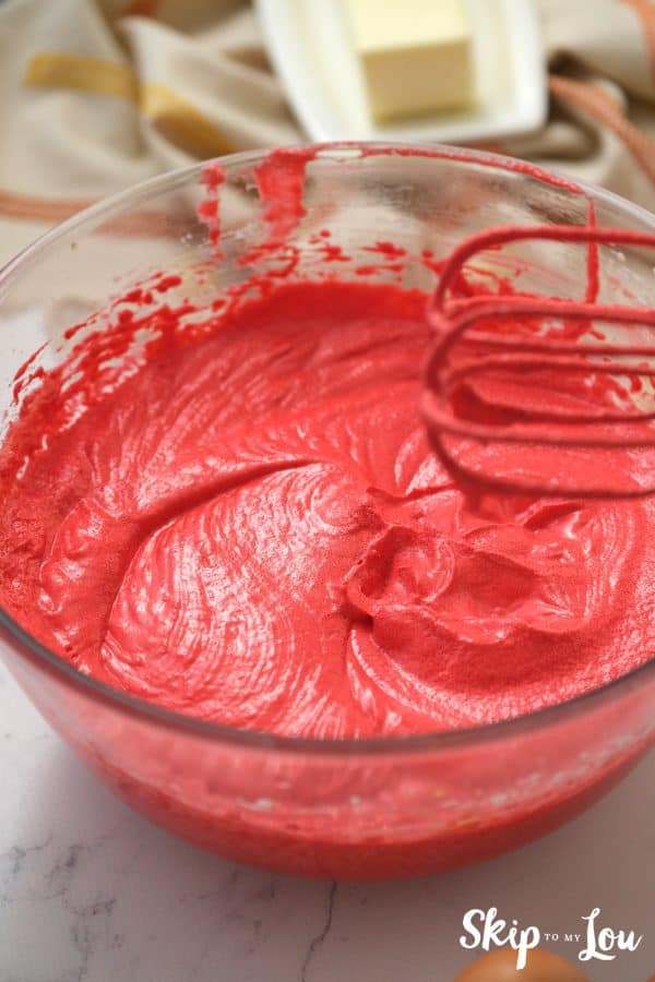 Glass mixing bowl and 2 beaters with Red Velvet brownie batter on them, by Skip to my Lou.