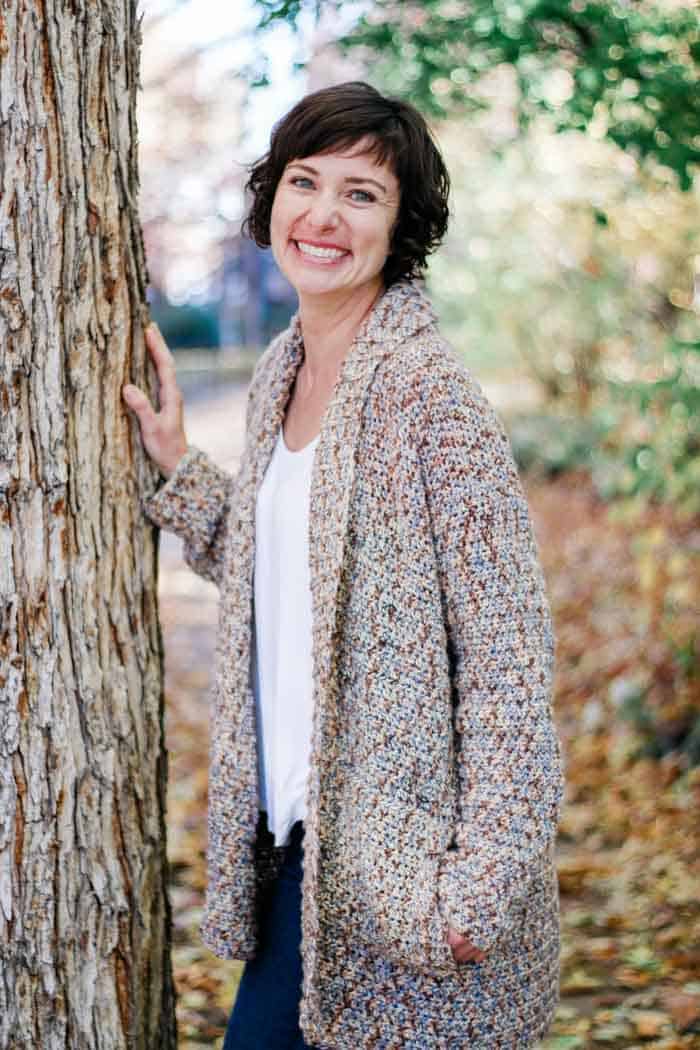 woman wearing beginner cardigan sweater pattern to crochet
