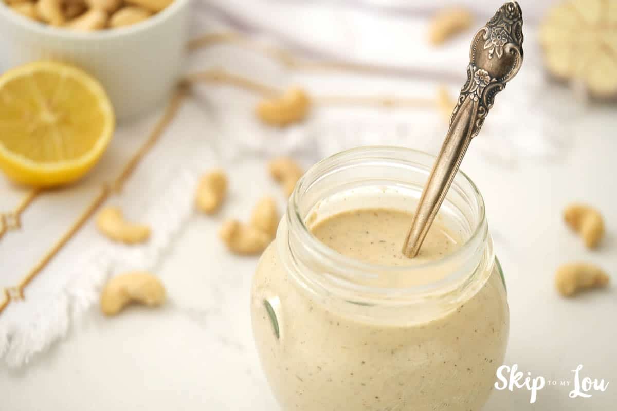 dairy free creamy Italian salad dressing in a clear glass jar with a silver spoon, by Skip to my Lou.
