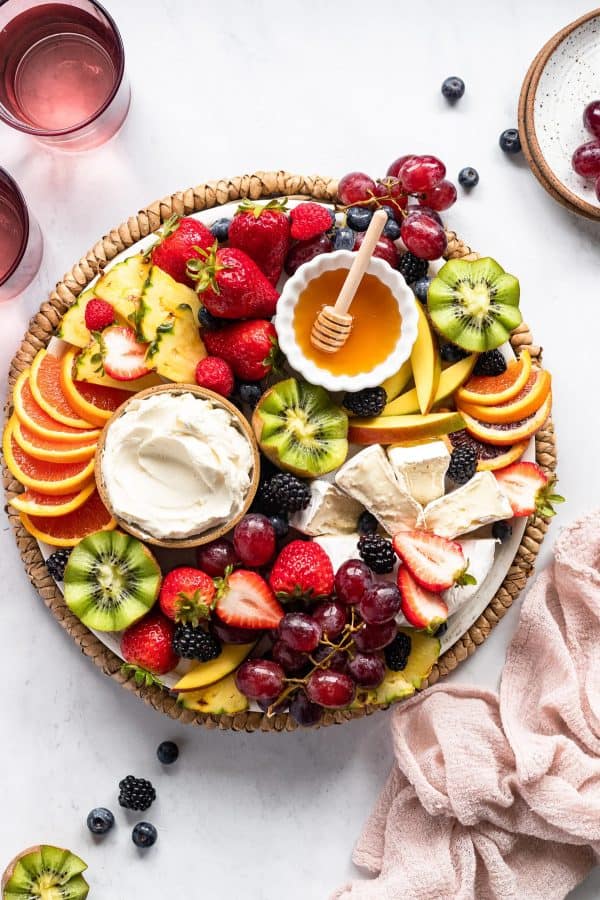 fruit charcuterie board ideas-fork in the kitchen-board with a variety of fruits with honey and a fruit dip.