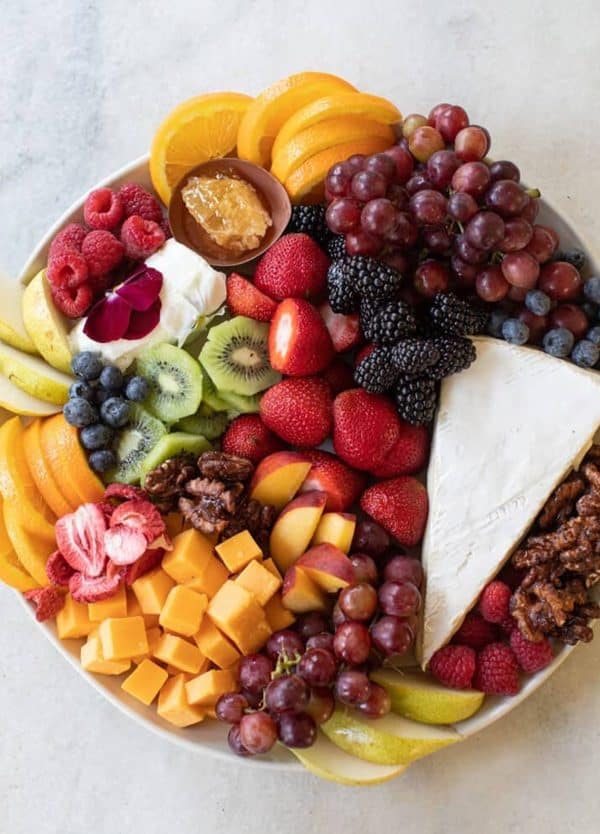 fruit charcuterie board ideas-sugar and charm-board with mange, grapes, kiwi, and brie