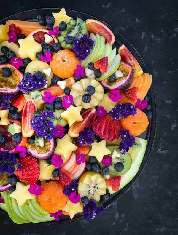 fruit charcuterie board ideas-the devil wears salad-board with a variety of bright fruits like kiwi, oranges, etc.