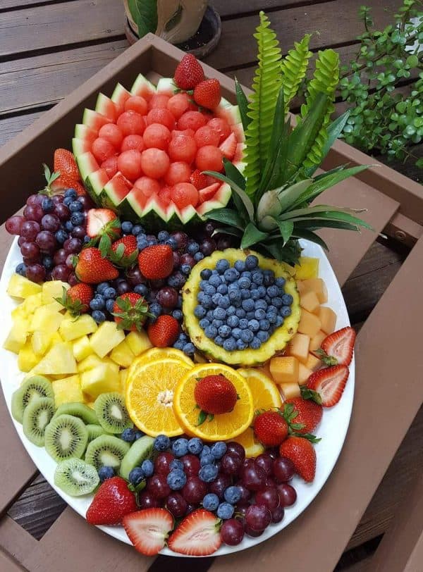 fruit charcuterie board ideas-wine with paige-board with a variety of fruits in hollowed out fruit like watermelon and pineapples.