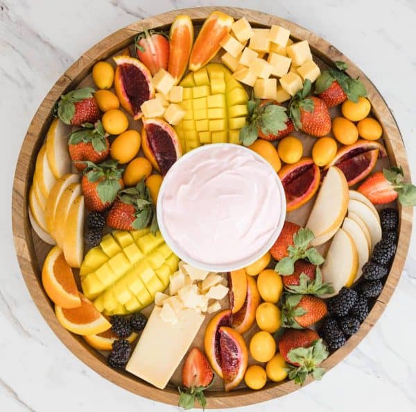 a fruit and cheese charcuterie board idea with a cream cheese dip in the middle from devour dinner