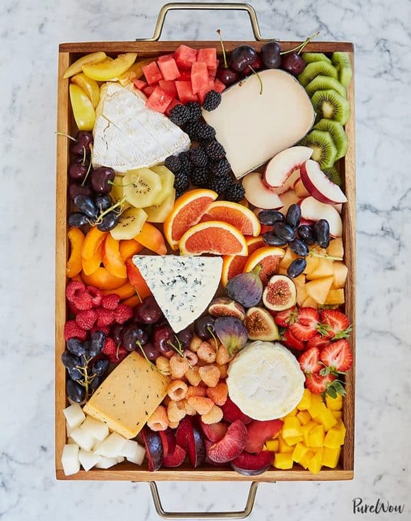 A fruit tray with a variety of different and unique fruits like golden kiwi and raspberries from pure wow.