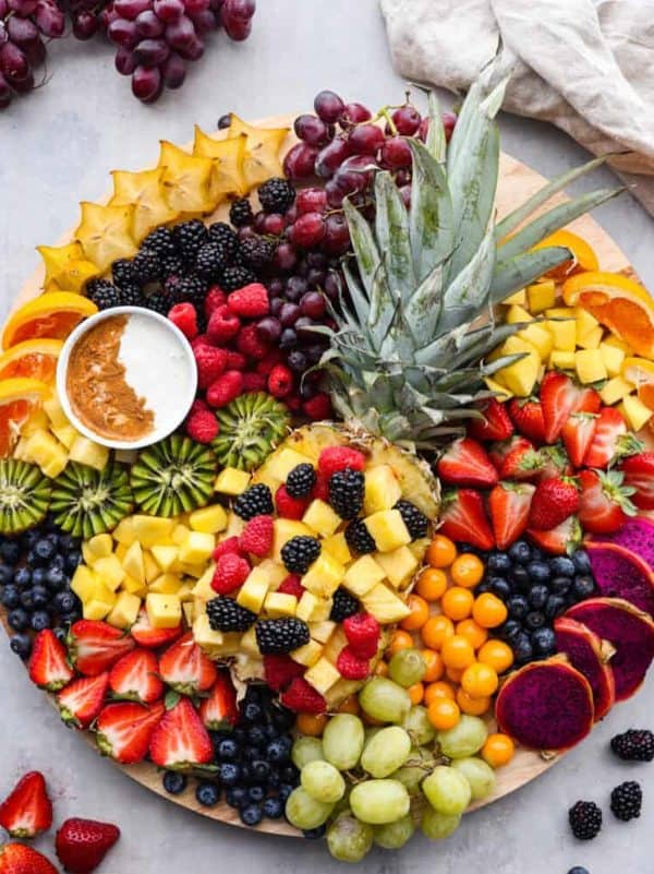 the recipe critic with a unique board and fruits including a hollowed out pineapple with fruit choices. 