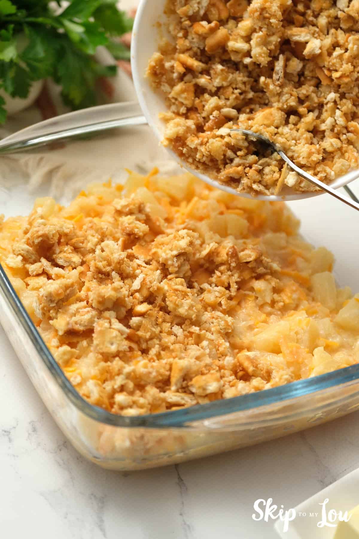 In a square glass baking dish, Pineapple Casserole, by Skip to my Lou.