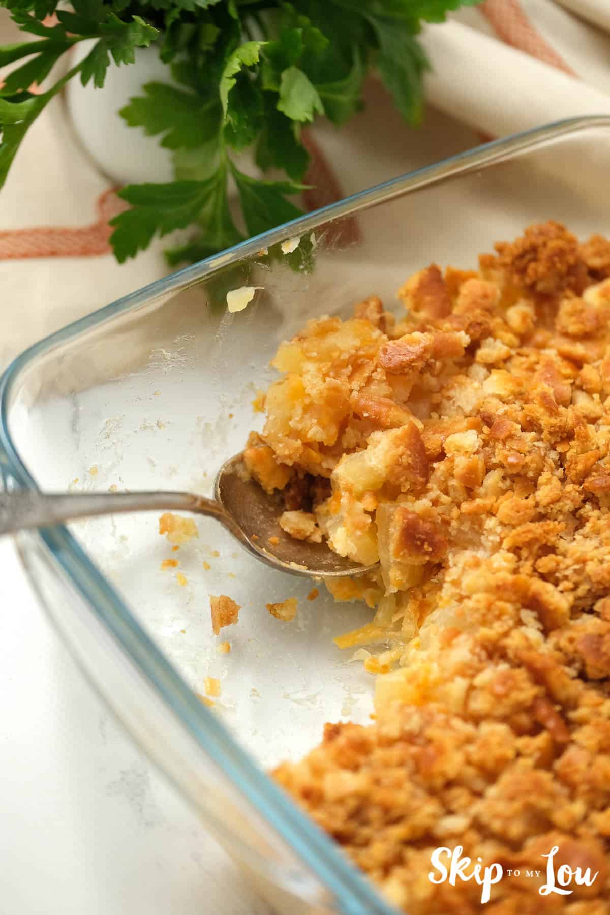 Pineapple Casserole served with a spoon, by Skip to my Lou.