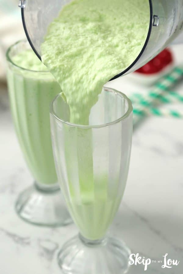 shamrock shake from Skip to my Lou recipe pouring from a blender into a tall glass