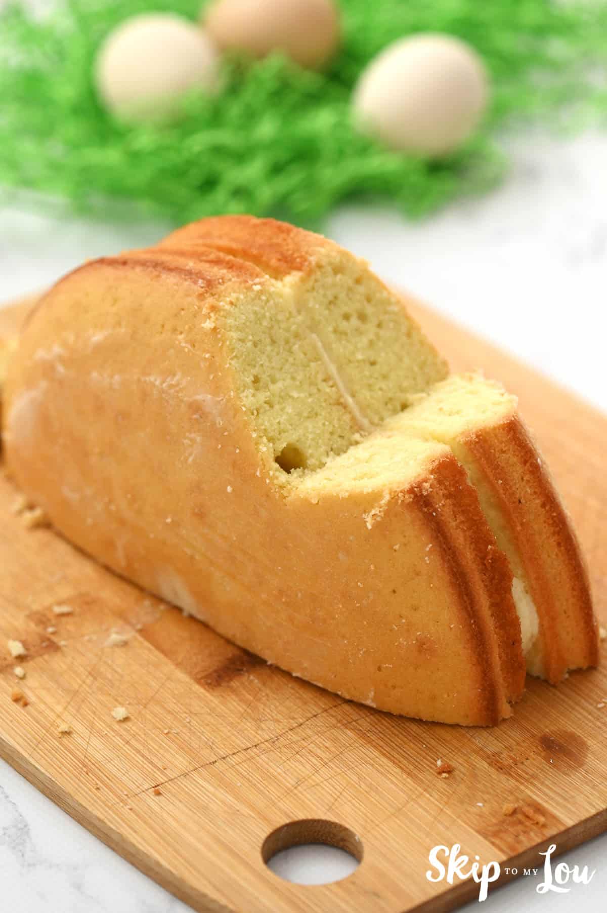 Two half cake layers, frosted together, standing upright and sliced to look like a bunny, by Skip to my Lou.