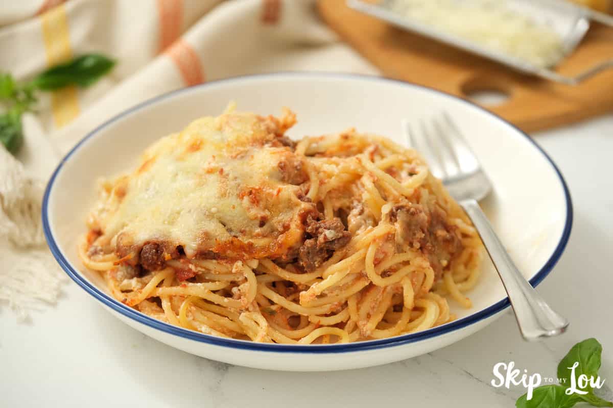 A bowl full of Spaghetti Alfredo casserole with a fork, by Skip to my Lou.