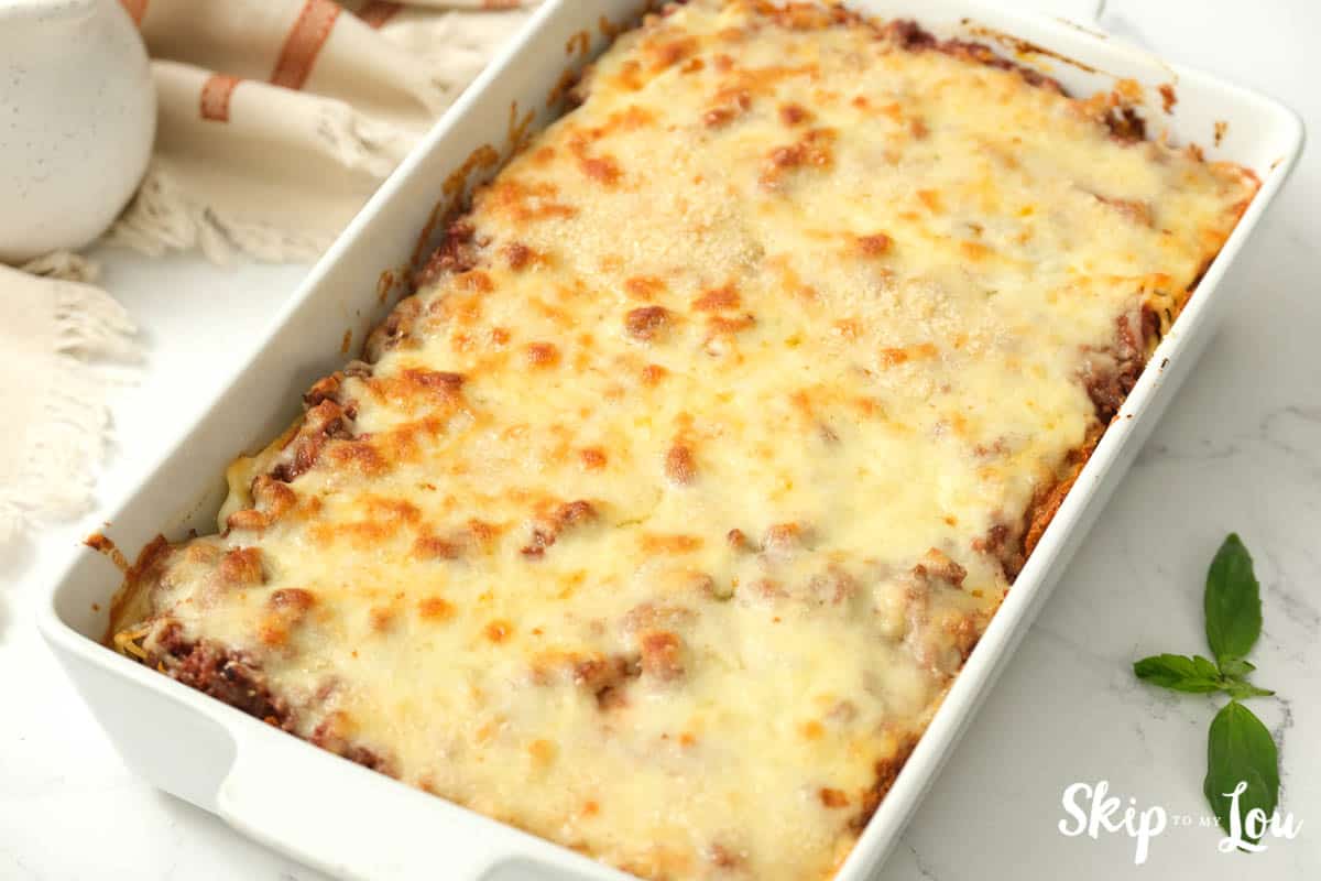 Baked Alfredo Spaghetti pasta casserole in a white rectangular baking dish, by Skip to my Lou.