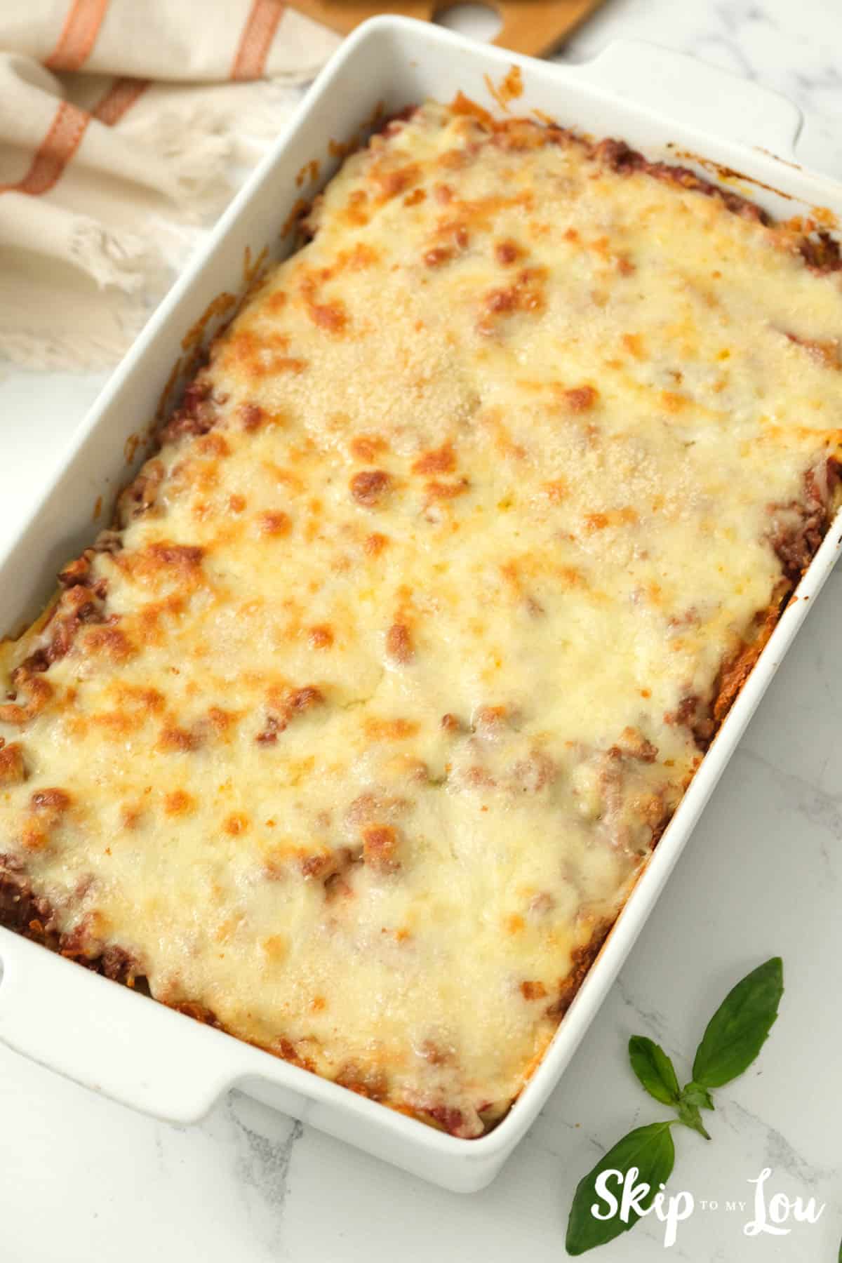 Alfredo Spaghetti baked in a rectangular white baking dish, by Skip to my Lou.