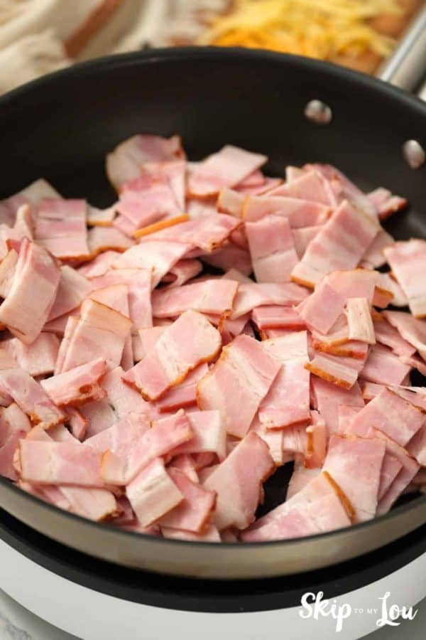 chopped bacon placed in a pan prior to cooking for egg strata from Skip to My Lou recipe