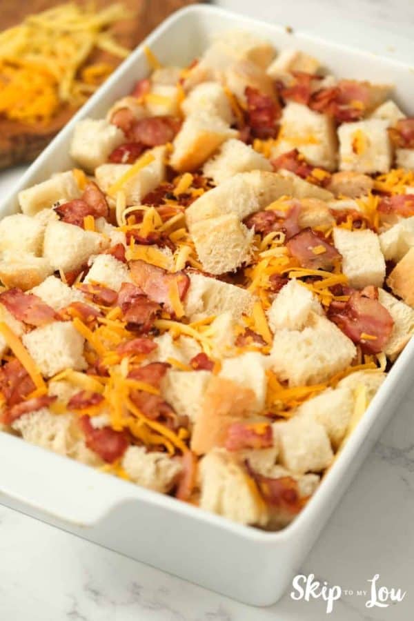 bread, cheese and bacon in casserole dish for egg strata from Skip to My Lou recipe