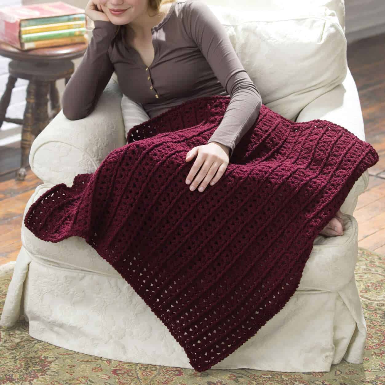 woman with burgundy lap throw on lap sitting on couch