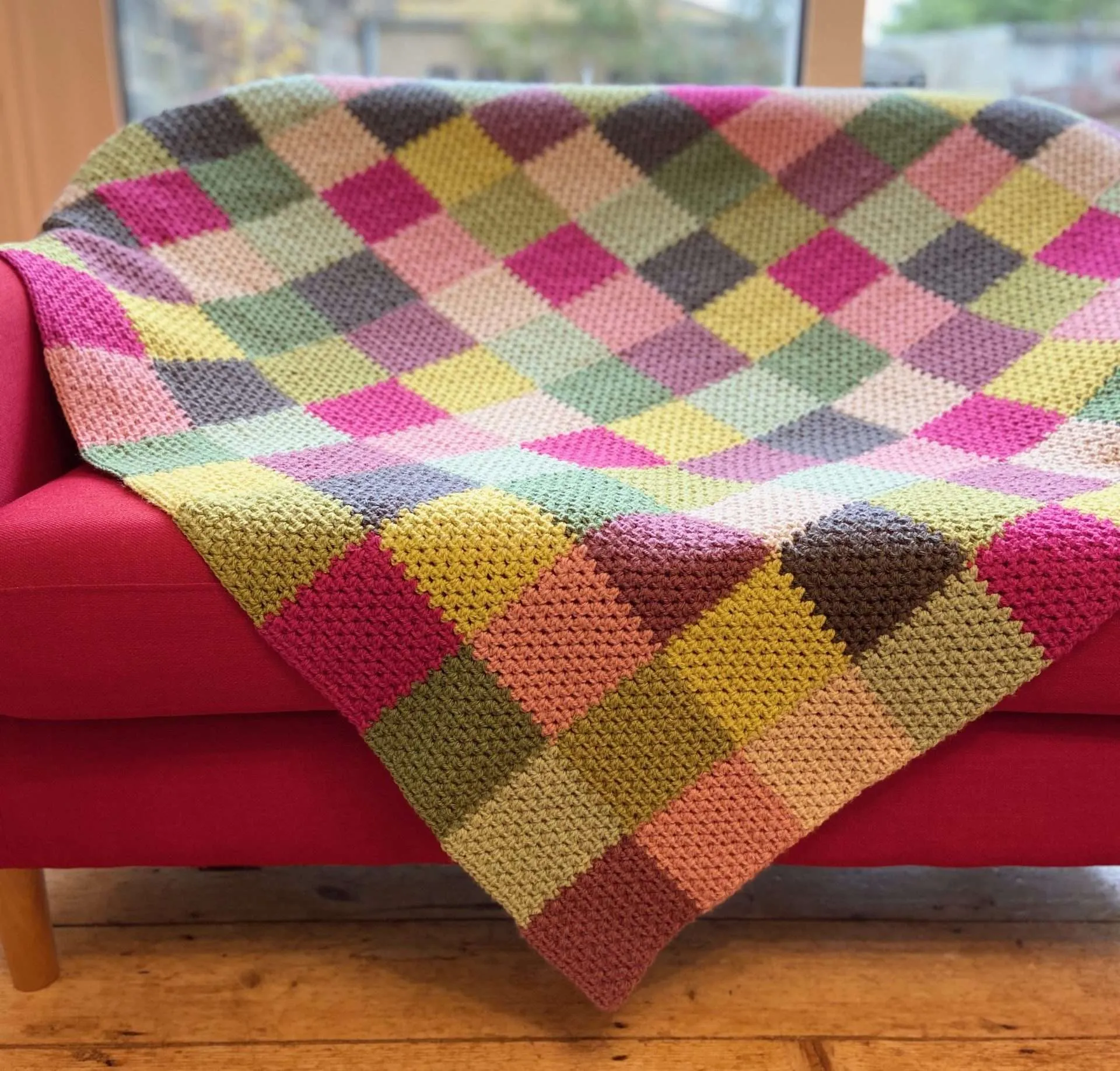 rainforest patchwork blanket draped over a couch
