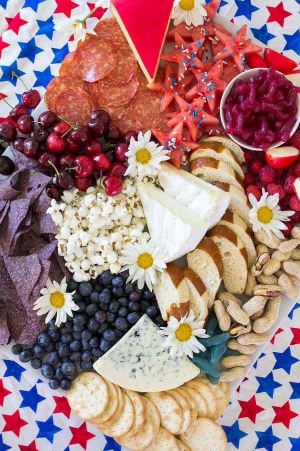 daisies accent this board from freutcake with watermelon stars, gummy lobsters, bread, and cheese. 